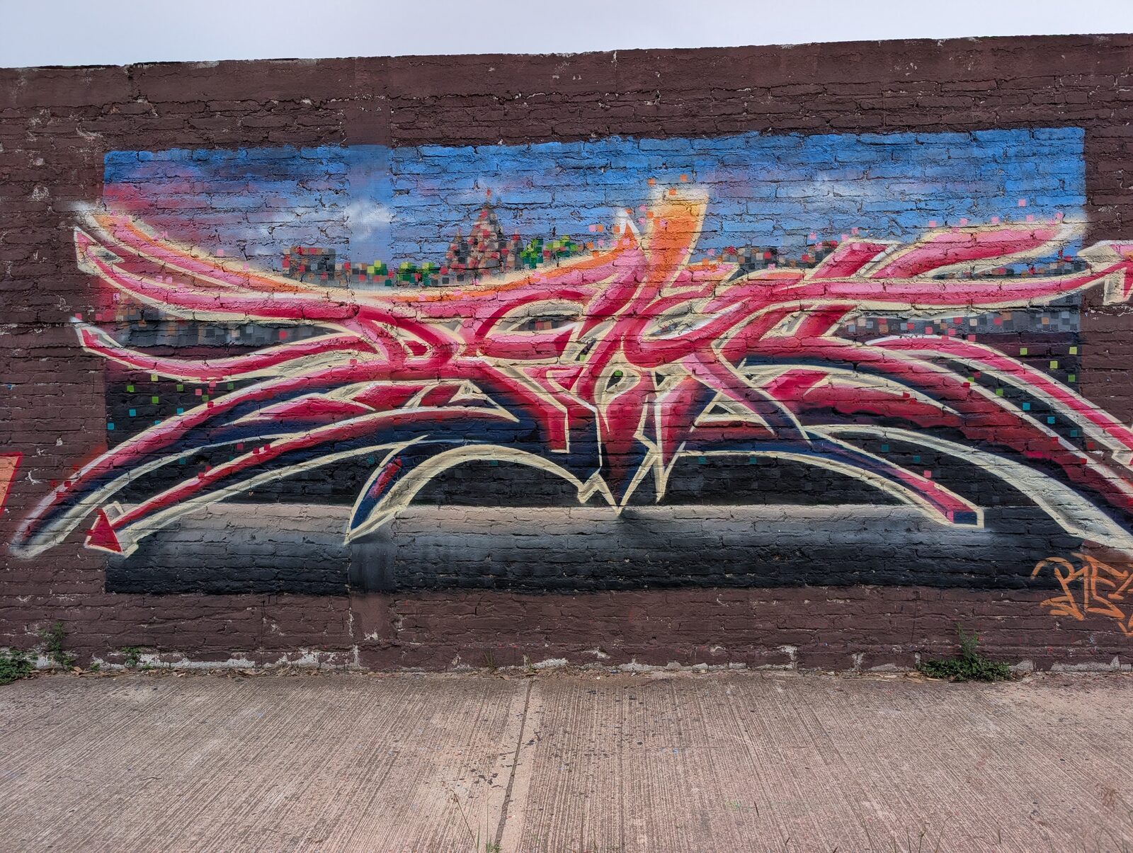 Grafiti rosa sobre una silueta urbana